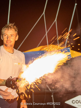 Portrait de Thomas Ruyant, torche en main pour célébrer sa victoire en IMOCA lors de la route du rhum 2022